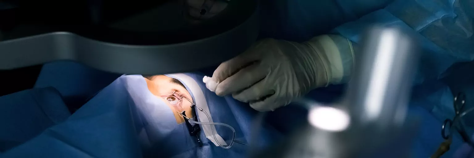 Photographie de chirurgiens réalisant une intervention sur l'oeil d'un patient au bloc opératoire